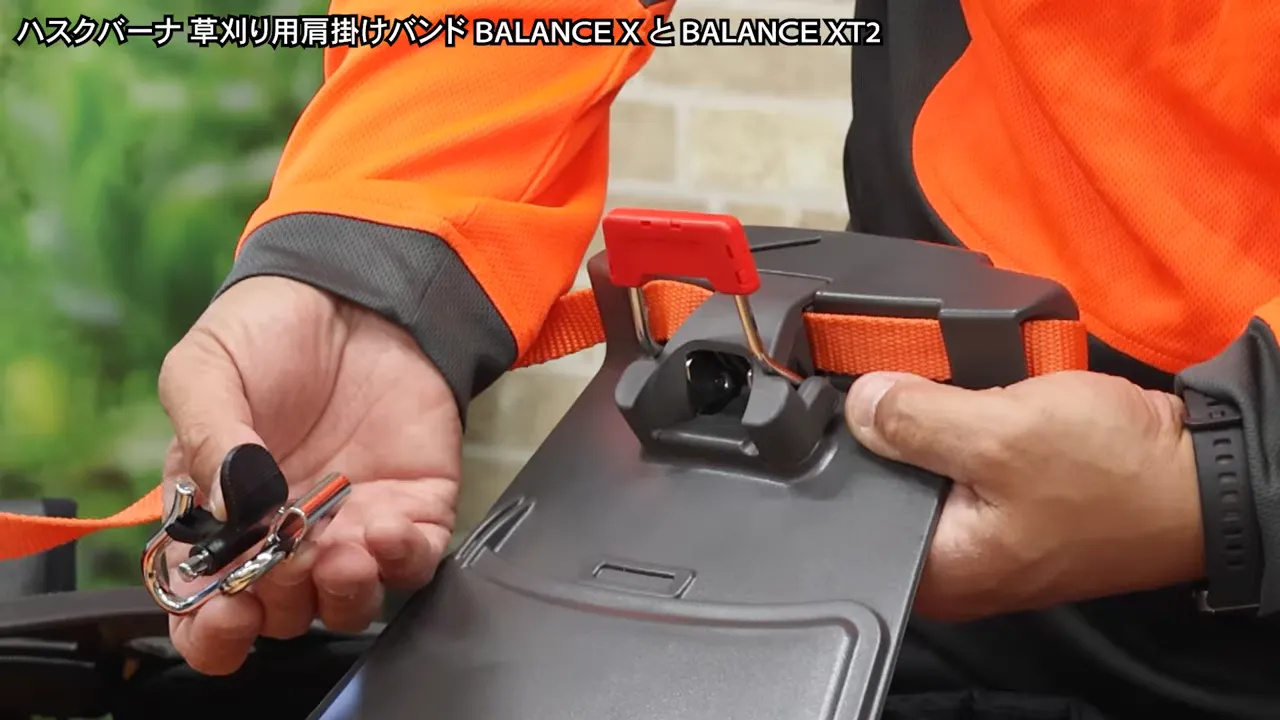 ハーネスのフック機構を手元で外して見せている接写