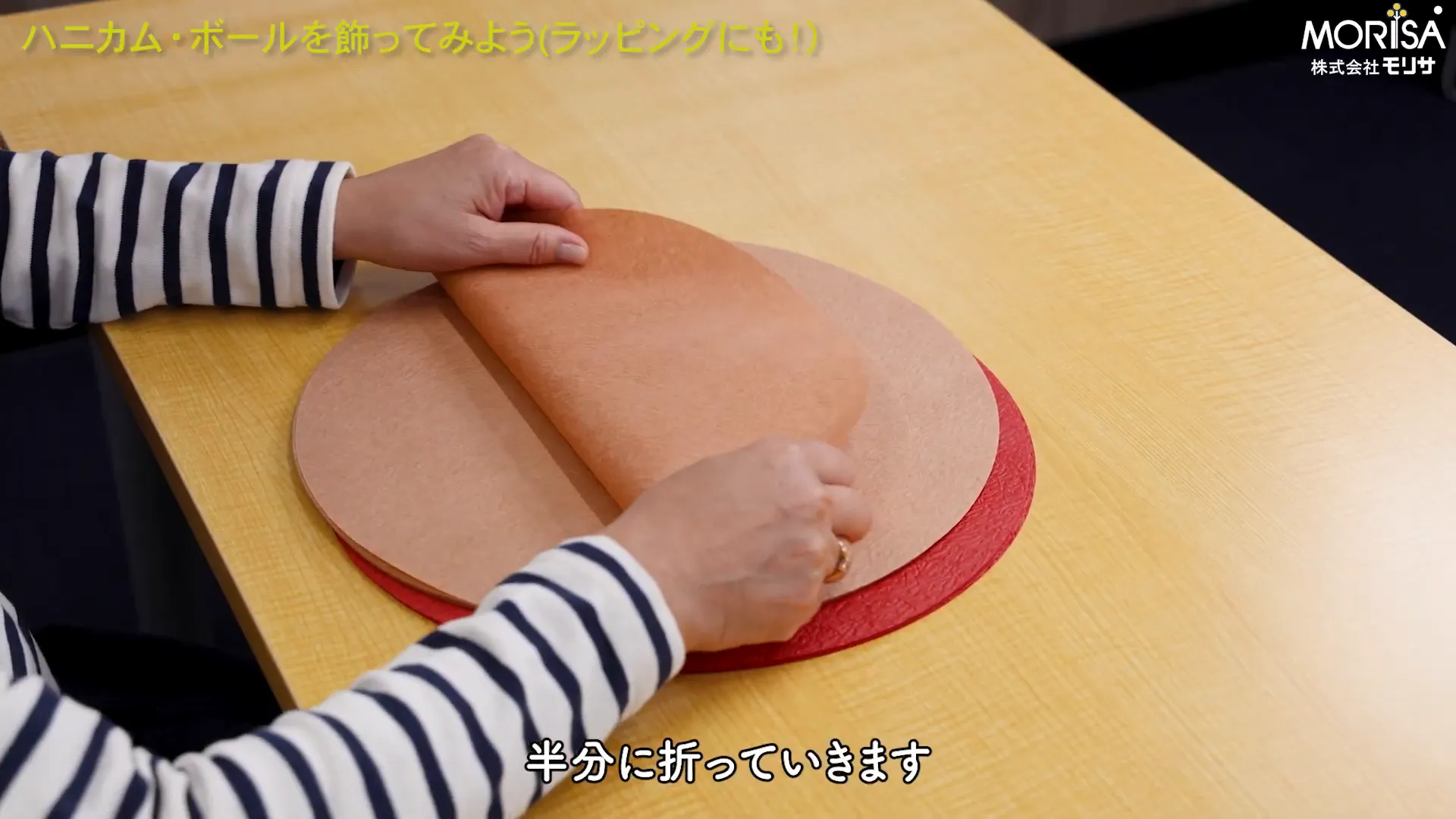 円形紙を半分に折る様子
