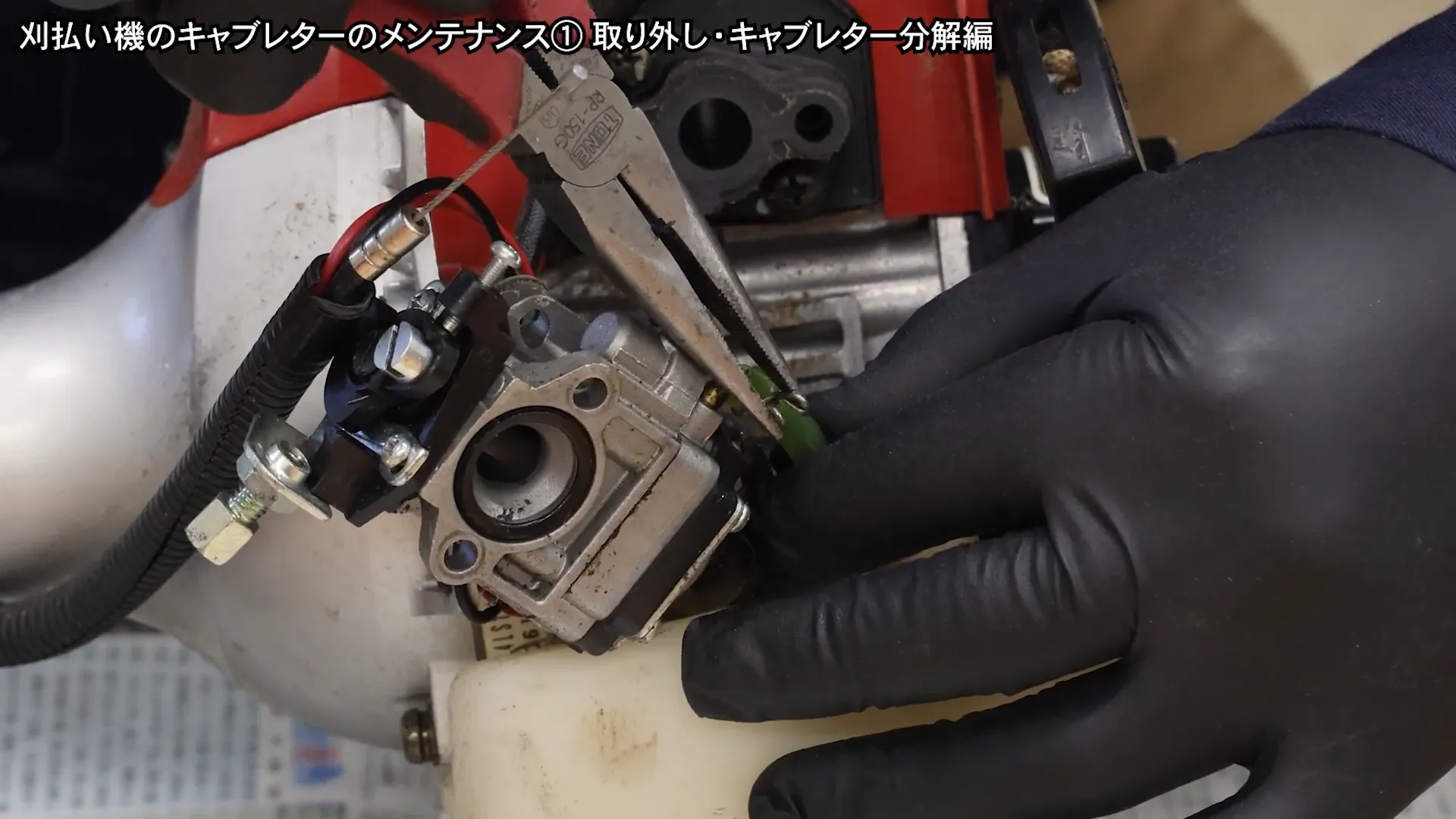 ラジオペンチを使って燃料ホースを外す様子