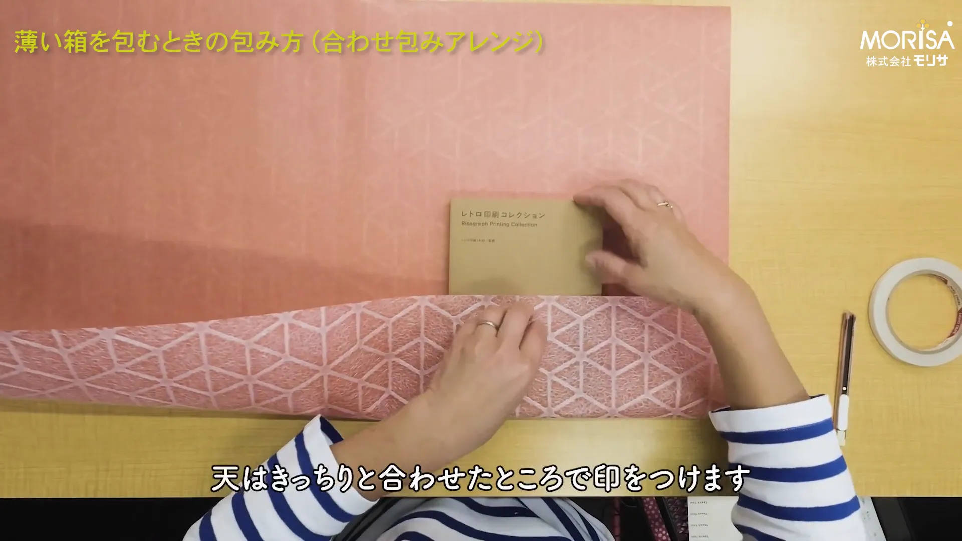 本のサイズに合わせて紙に印をつける様子