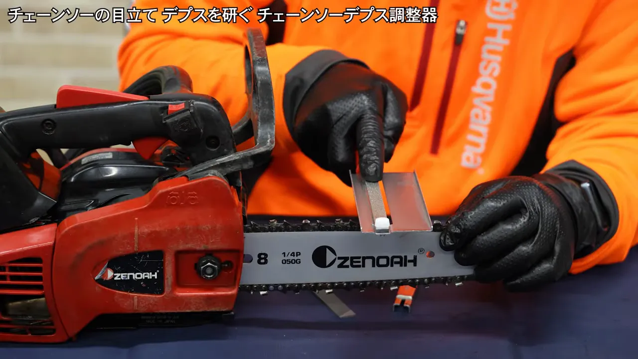 integrated depth gauge tool placed across the chainsaw teeth with a diamond file in the center