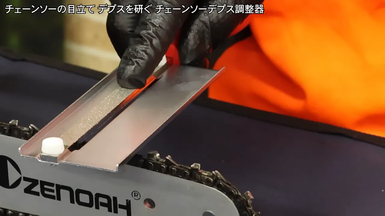 close-up of the depth adjuster laid flat across the chain teeth while being aligned by hand