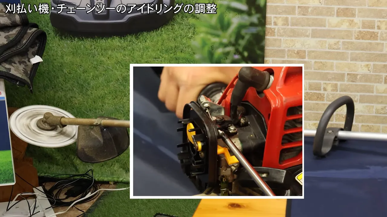 刈払機のキャブレターにドライバーを当て、アイドリングを下げるためにネジを回している様子。刃が左で回転している。