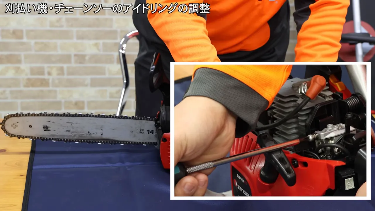 カバーを外したチェーンソーのキャブ付近を近接撮影し、ドライバーでネジを調整しようとしている画像