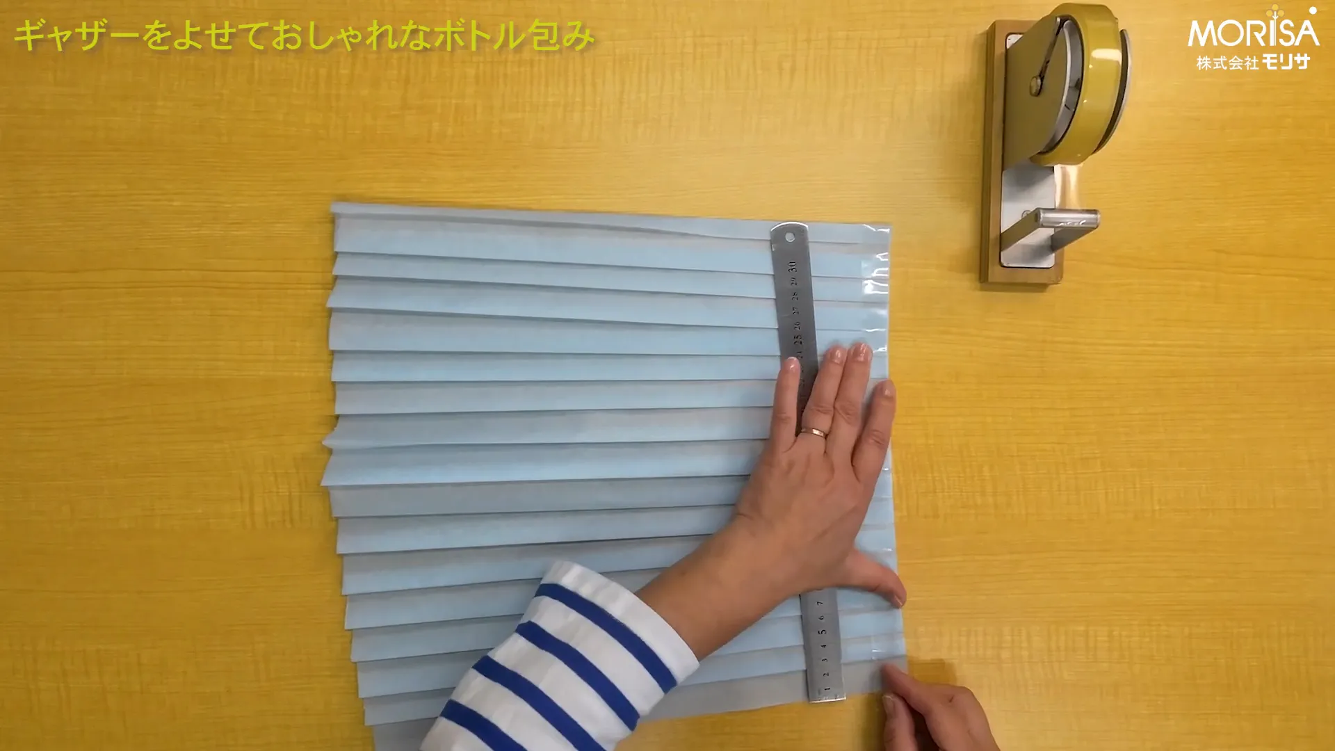 ギャザーの底部分をセロハンテープで固定している様子