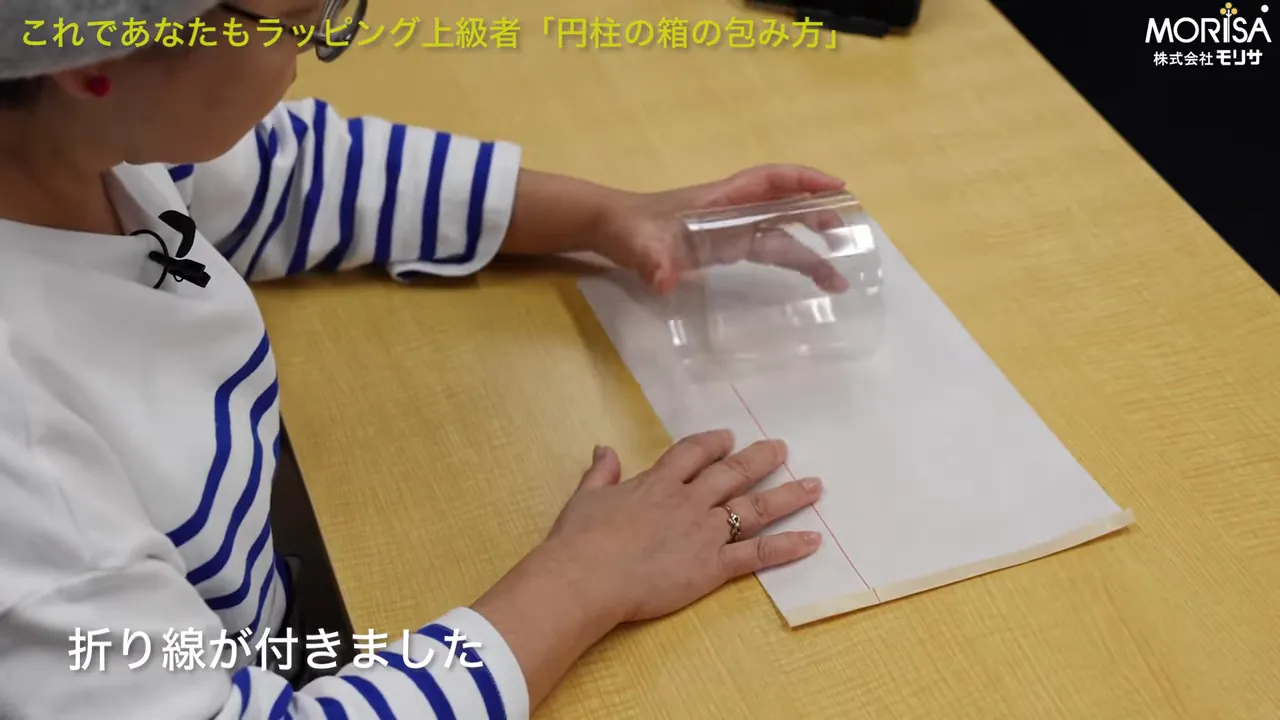 赤い合わせラインに沿って透明な円柱を置き、重なり位置を確認する手元の写真