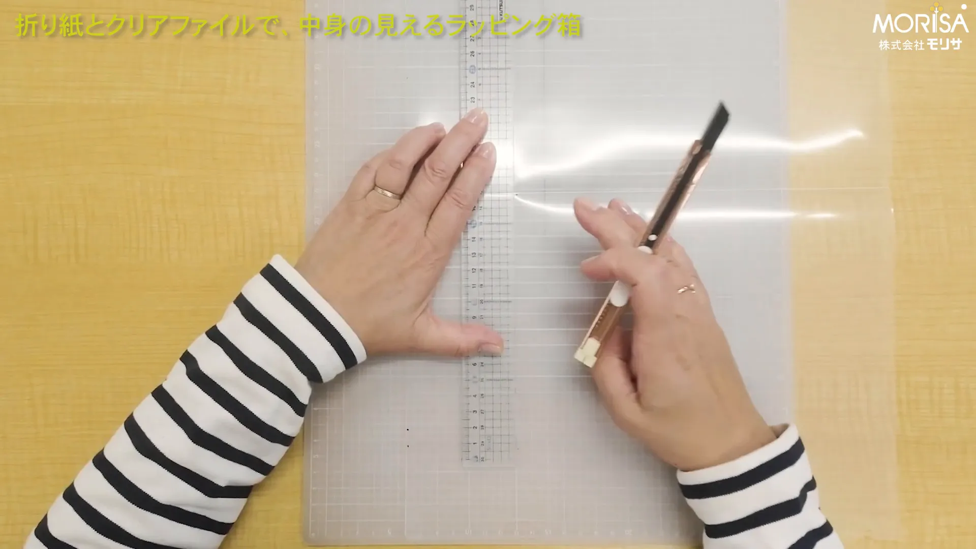 カッターマットの上でクリアファイルを切っている様子