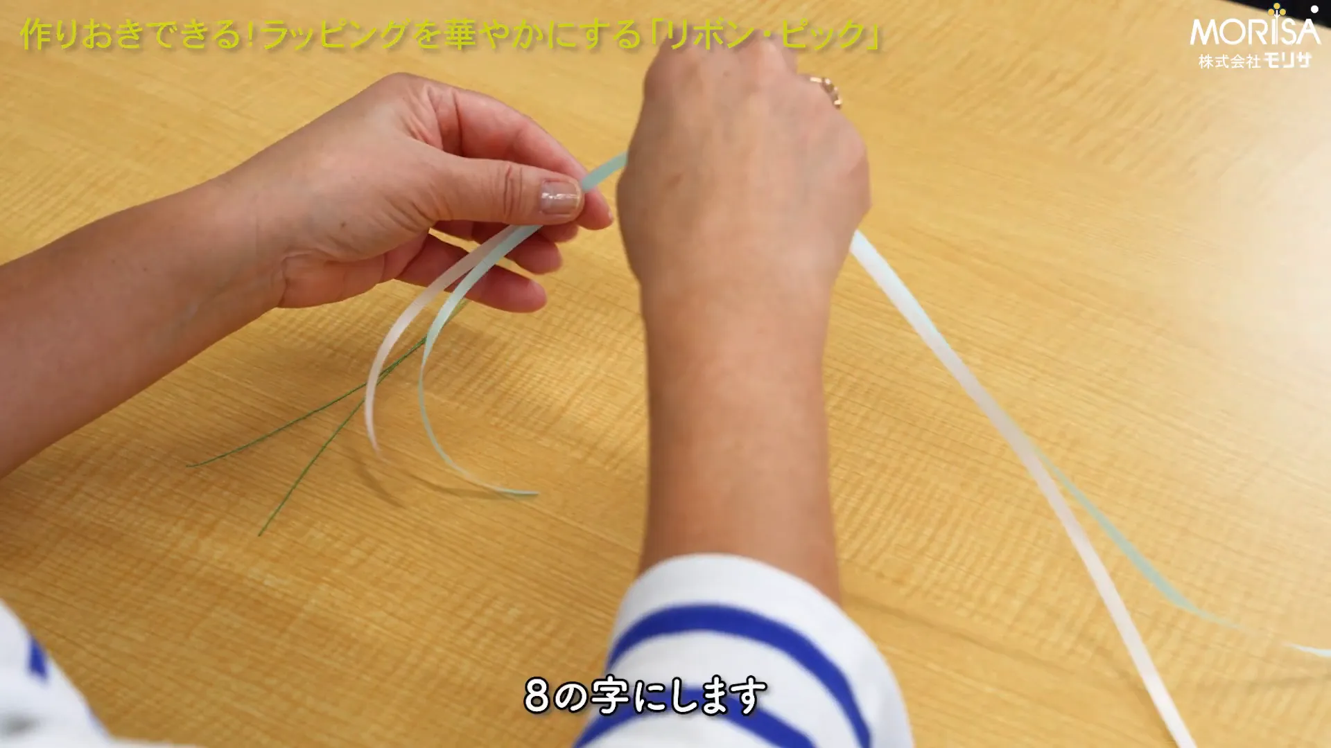 2色のカーリングリボンで8の字を作る様子