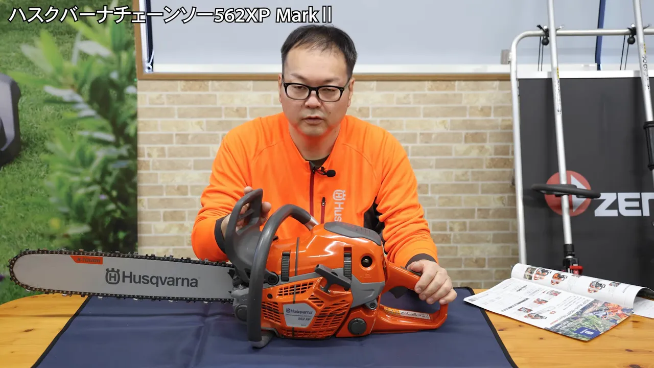 テーブル上に置かれたハスクバーナ562XP Mark IIを前に説明する講師と本体のクローズアップ