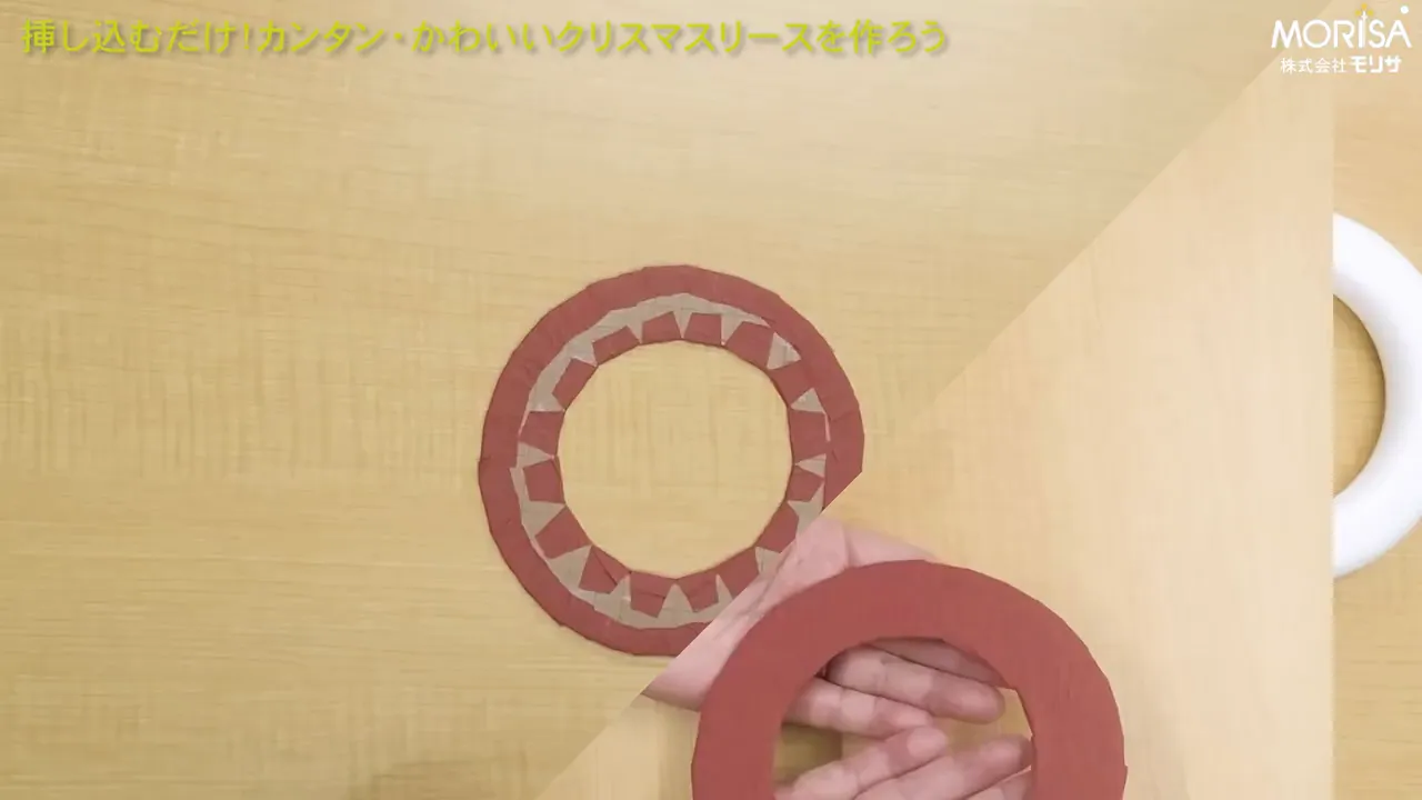 机上に置かれた和紙で包んだリース土台の裏側と、手で持った別の円形パーツが見える俯瞰ショット