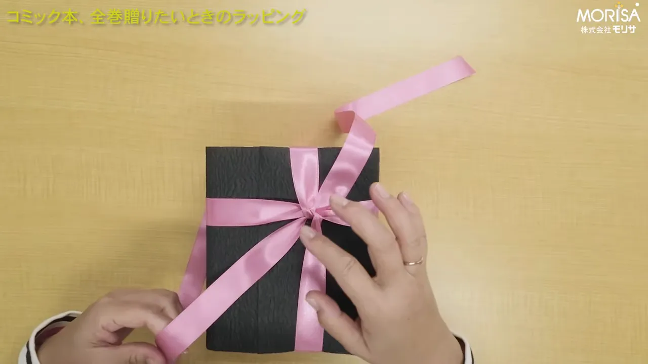 テーブルの上でリボンやオーナメントを配置しているところ