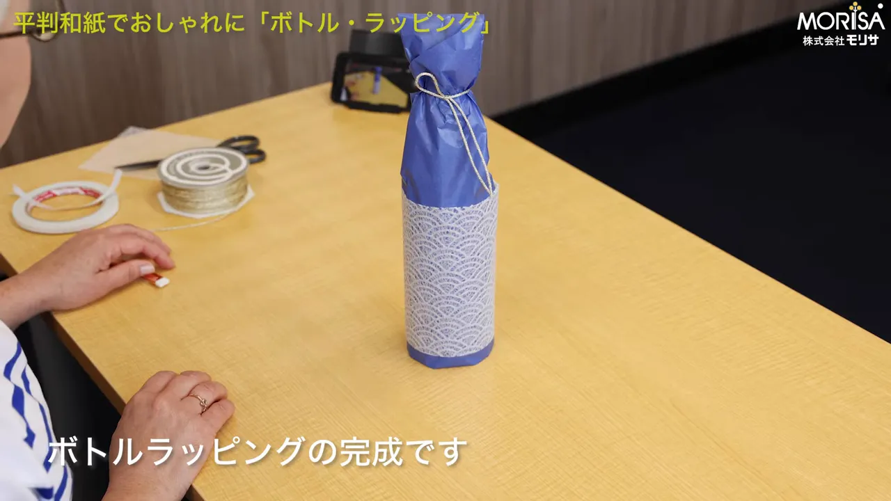 テーブルの中央に立てられた完成済みの包みボトル。全体がよく見える構図。