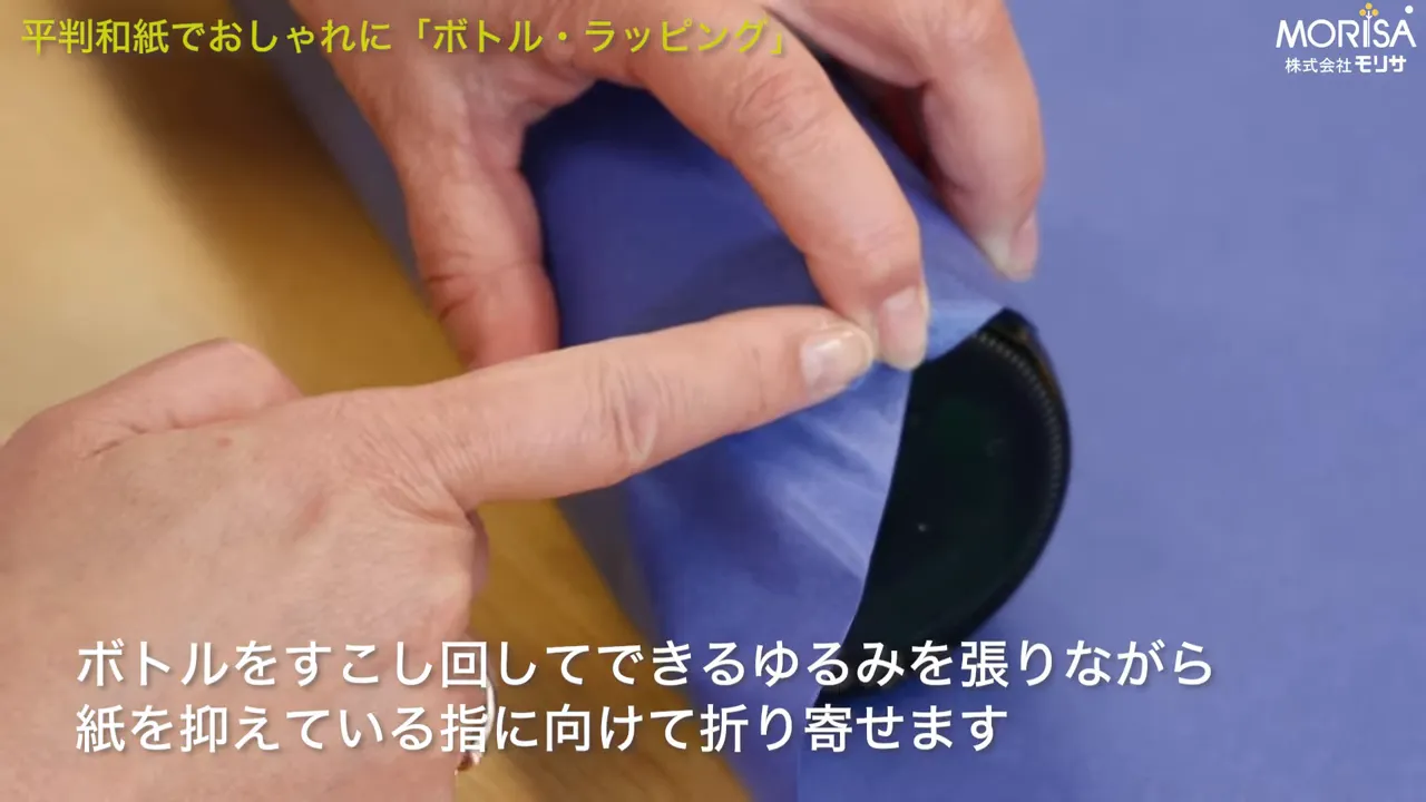 紙を一点に寄せてギャザーを作る指先のアップ。寄せ方が分かりやすい構図。