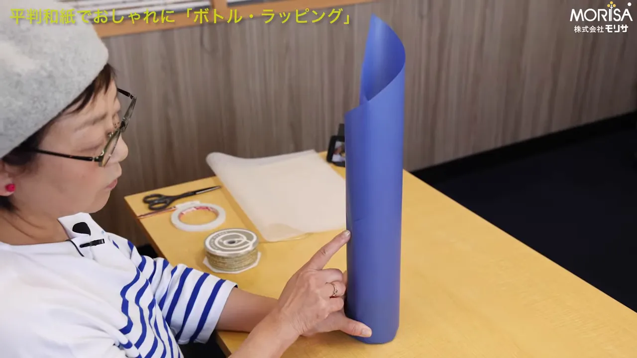 指で合わせ目を指している手元、両面テープで固定する位置がわかる