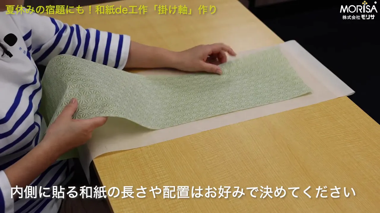 差し色の和紙を当ててバランスを確認している場面