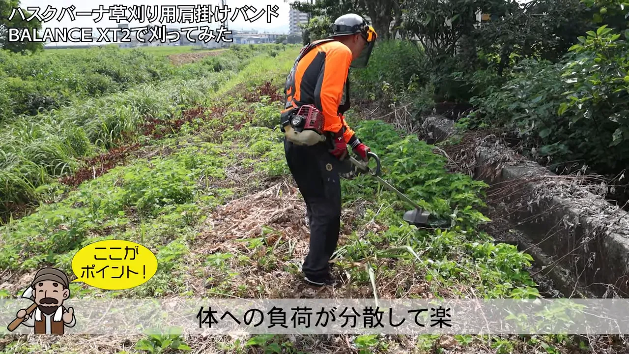 草地でハーネスを着用して刈払機を操作している様子