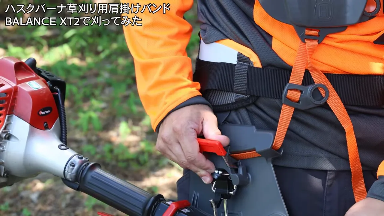 腰の横にある草刈機接続用の赤い解除レバー