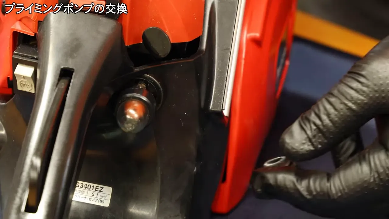 チェーンソーのプライミングポンプをこじ開けている様子