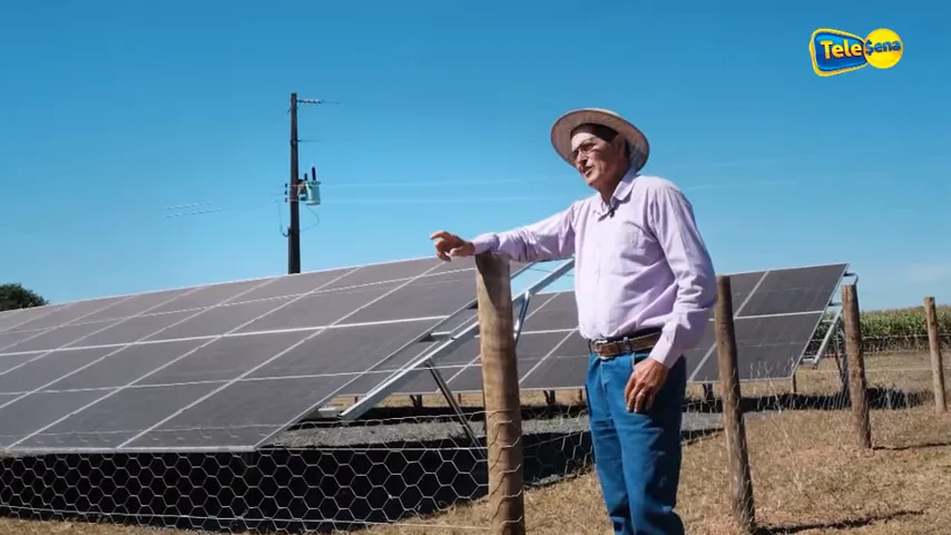 Vista aérea de painéis fotovoltaicos em terreno rural com texto energia solar