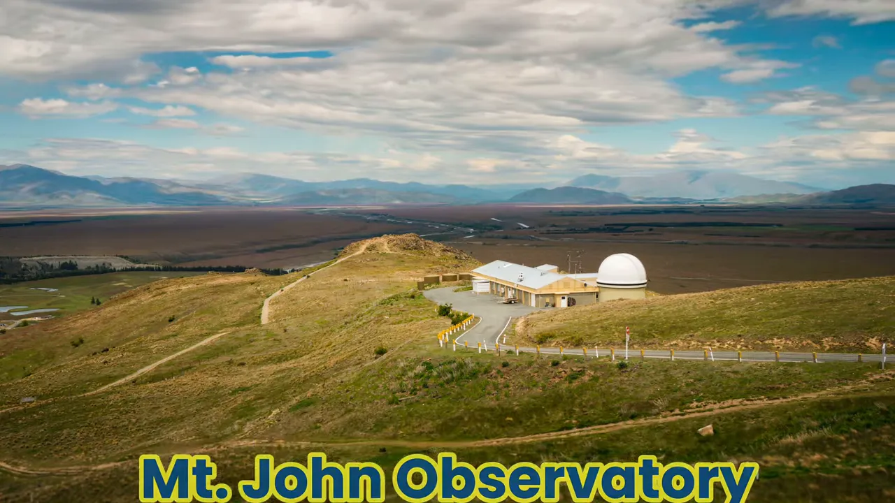 Mount John Observatory dome and buildings on a hill with wide Mackenzie plains and mountains beyond, Lake Tekapo region.