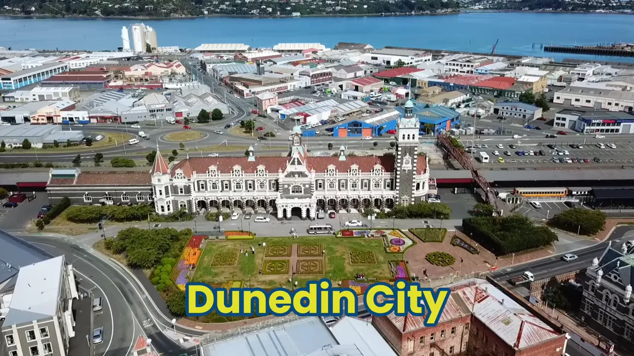 Aerial shot of Dunedin city railway station, formal gardens and nearby waterfront