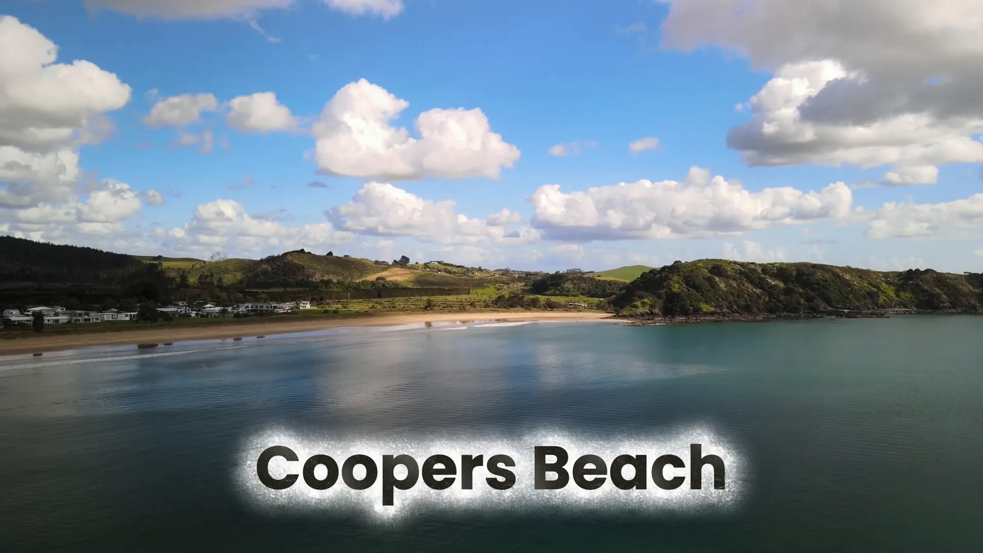 Coopers Beach with sandy shore and Pohutukawa trees in bloom - - New Zealand North Island Attractions