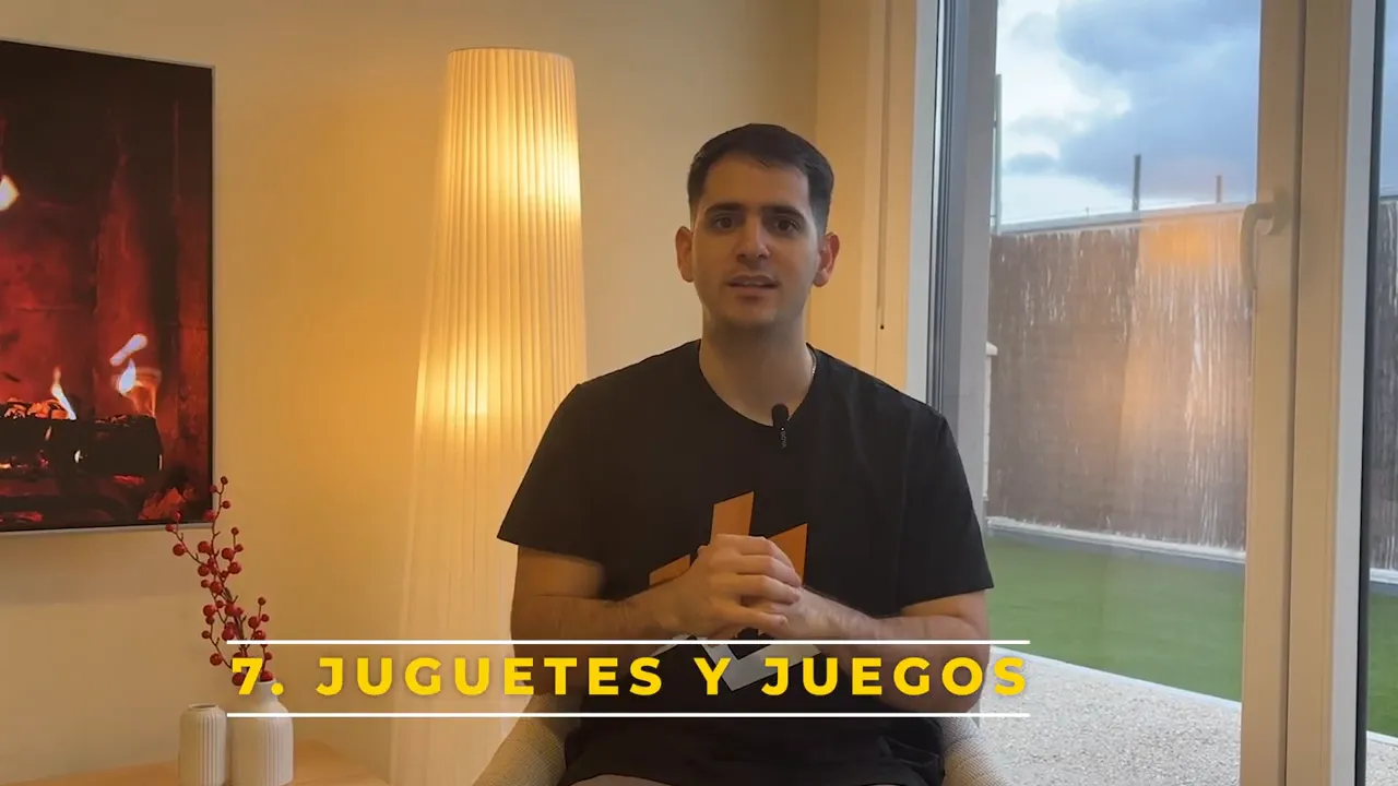 Plano del presentador con el rótulo grande '7. JUGUETES Y JUEGOS' en la parte inferior del vídeo