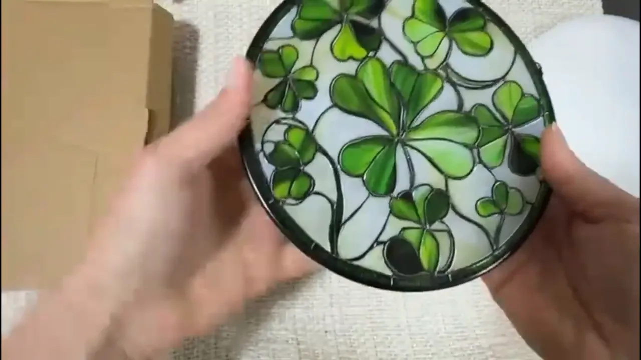 Close-up of stained glass lucky clover sun catcher showing green clover leaf design