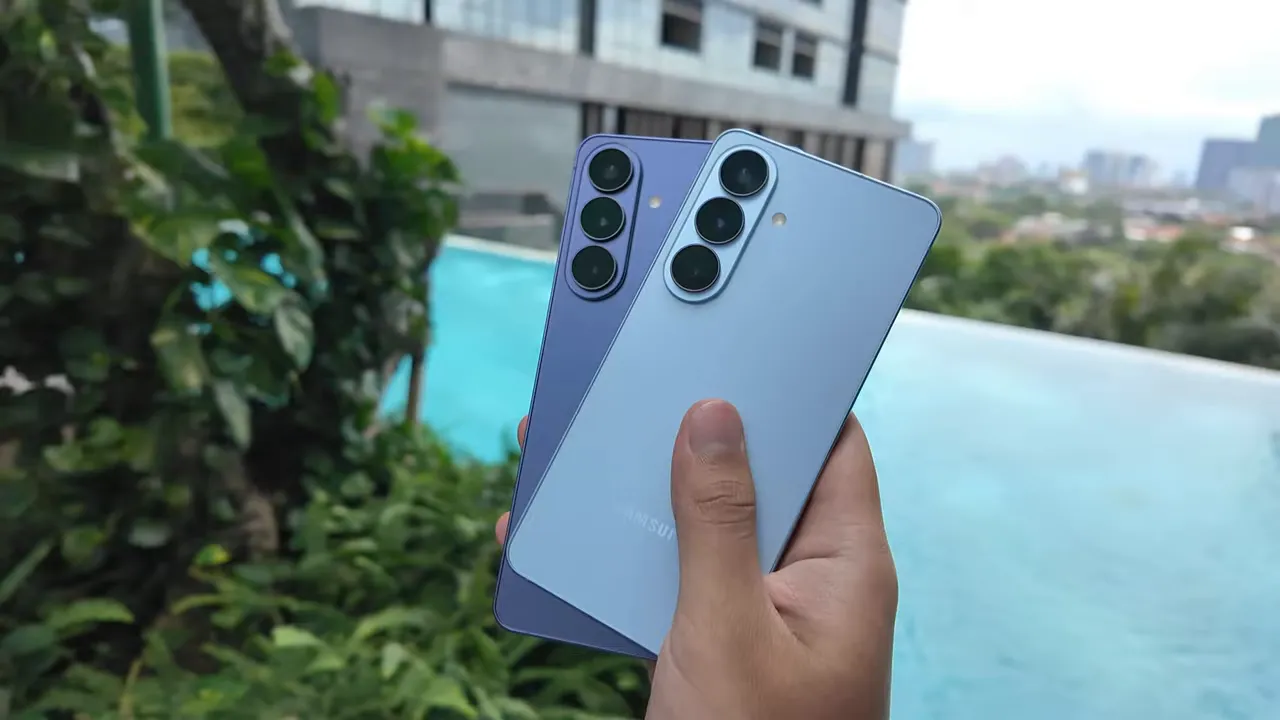 Dua unit Samsung Galaxy S26 dan S26+ dipegang berdampingan di depan kolam, menonjolkan modul kamera dan finishing