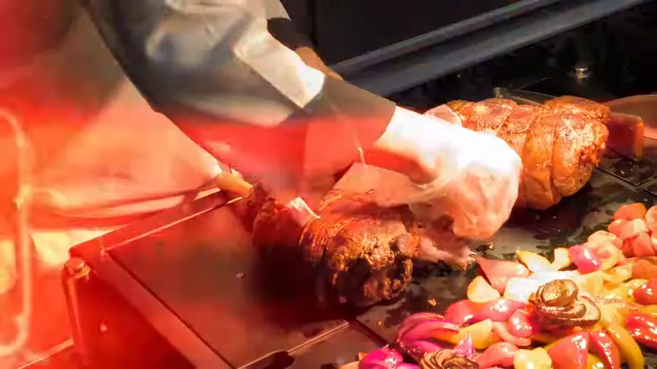 Pramusaji mengiris daging panggang di meja prasmanan gala dinner