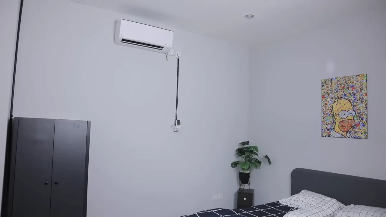 Kamar tidur dengan unit AC Daikin terpasang di dinding, memperlihatkan layout pengujian
