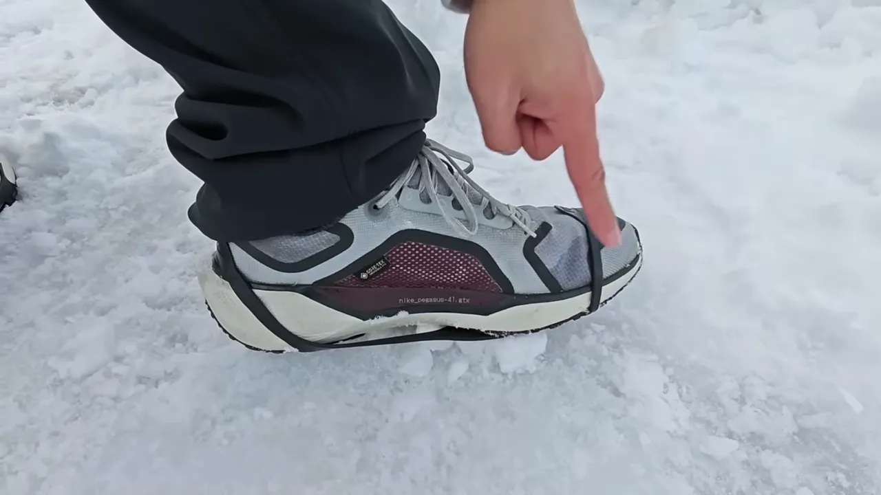 Nike Pegasus GTX dengan traction strap dipasang di permukaan salju
