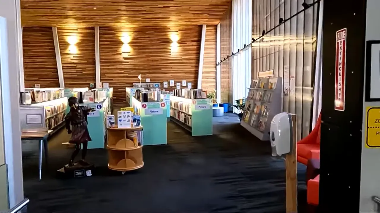 Interior children's section of the Prescott Valley library with low shelves, display table and warm wood ceiling.
