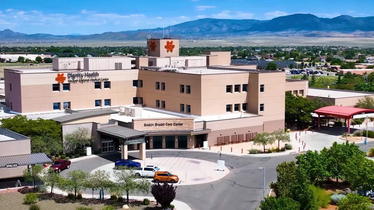 Aerial view of a regional hospital complex with surrounding parking and mountain backdrop
