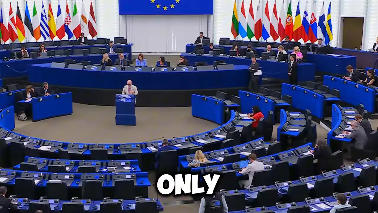 European Parliament chamber with curved rows of blue desks and national flags