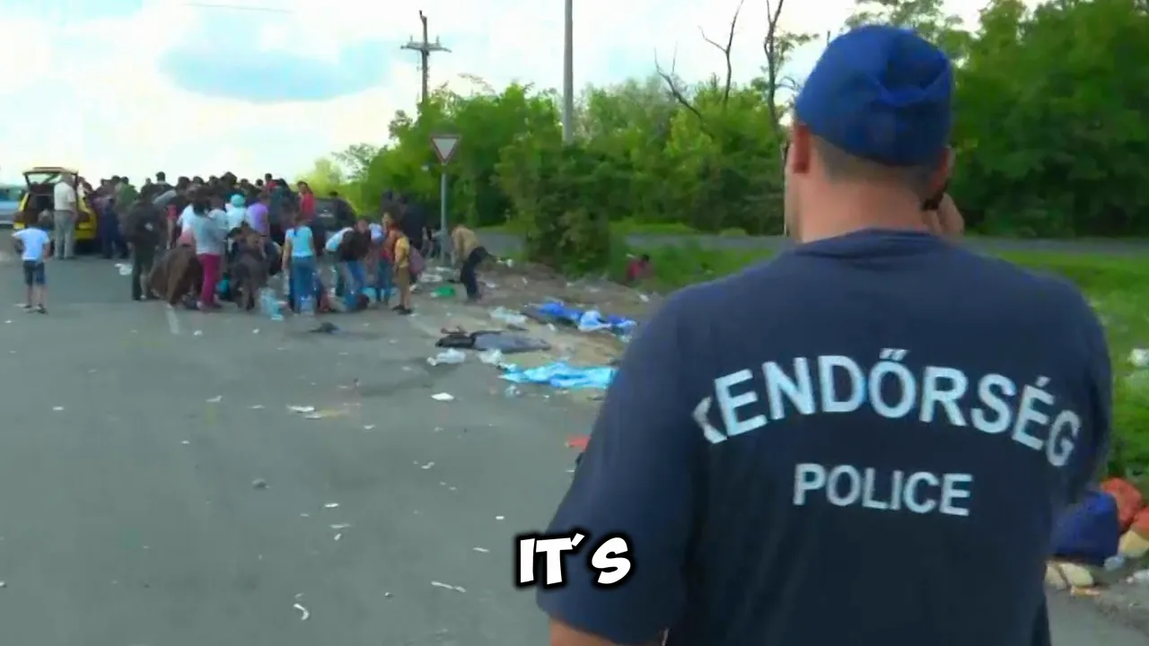 Police officer at a roadside migrant checkpoint with groups of migrants in the background