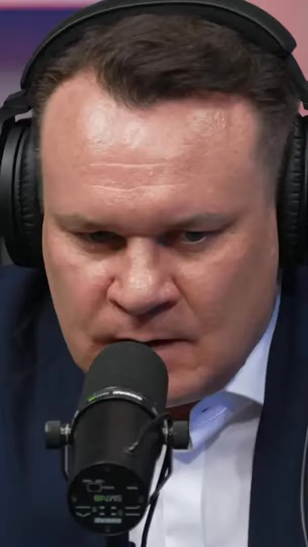 Dominik Tarczyński speaking into a microphone in a studio