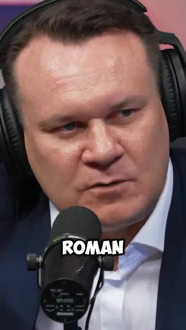 Dominik Tarczyński speaking into a studio microphone with the on-screen word “ROMAN”