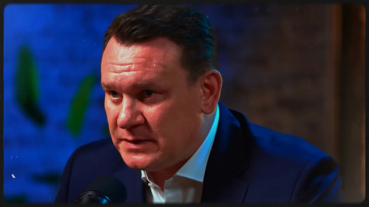 focused male speaker in navy suit at microphone