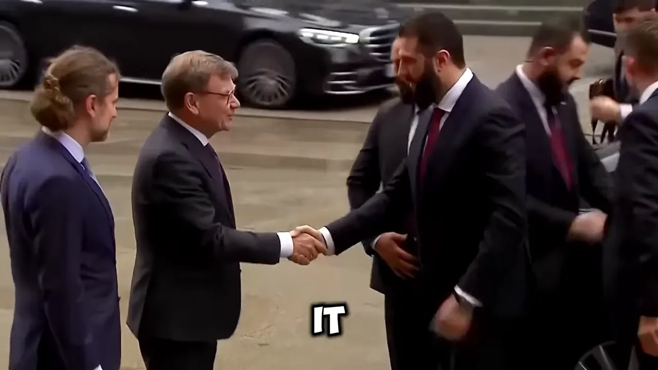 Officials shaking hands at a formal diplomatic event in front of military vehicles