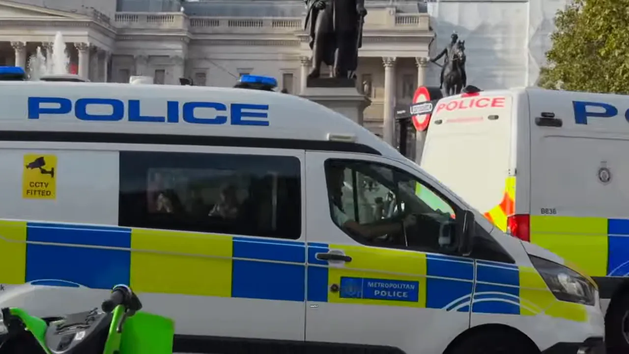Person in orange prison clothing holding jail bars