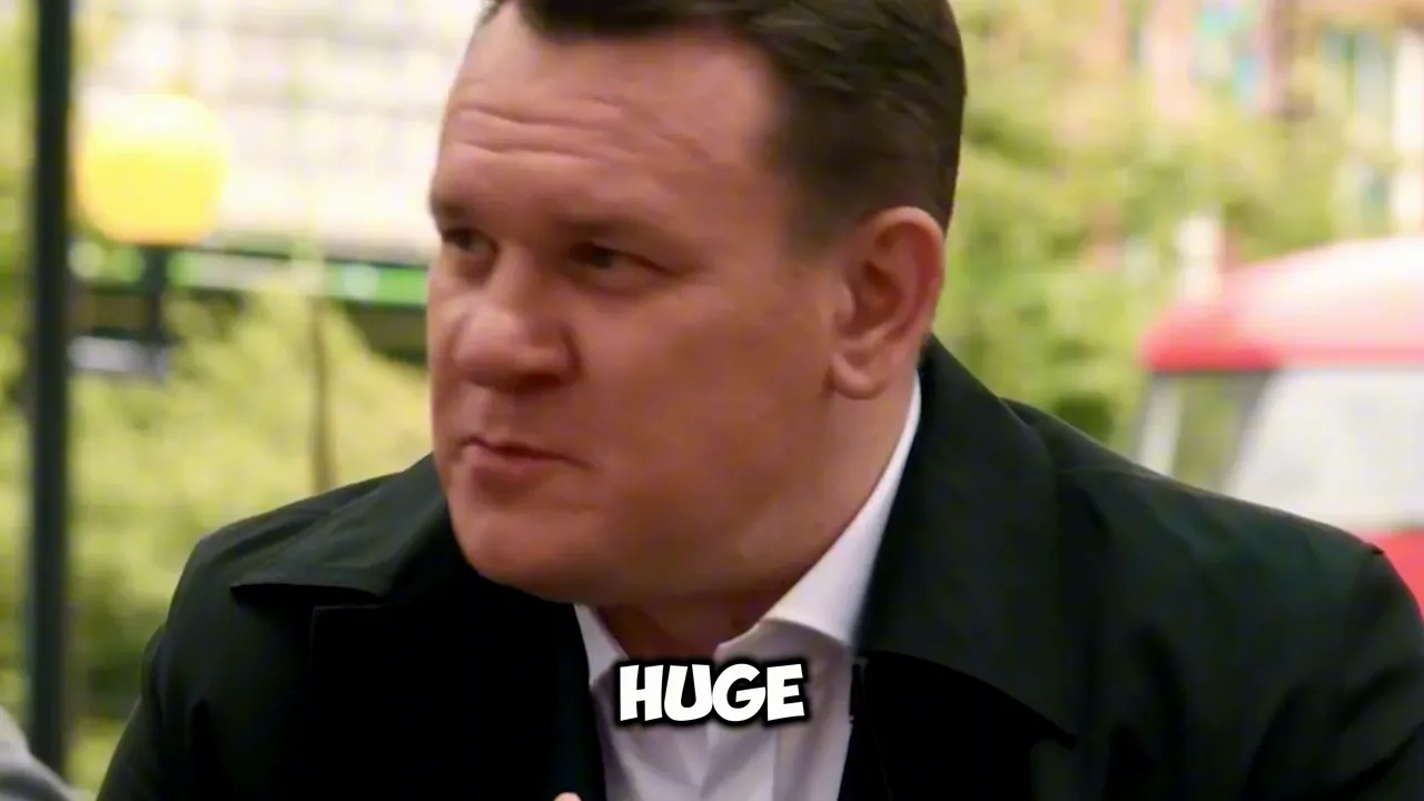 Close-up of a man speaking with the on-screen word 'HUGE' visible