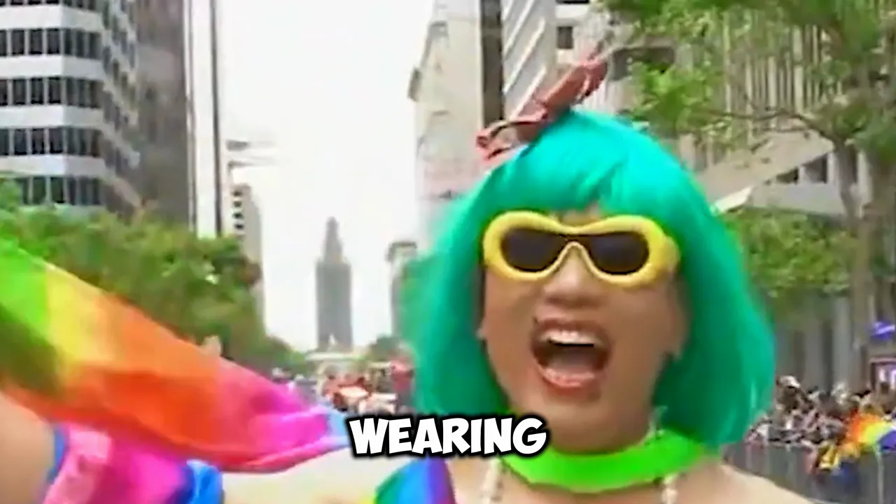 Participant at a Pride parade wearing a bright wig and yellow sunglasses, with parade crowd behind