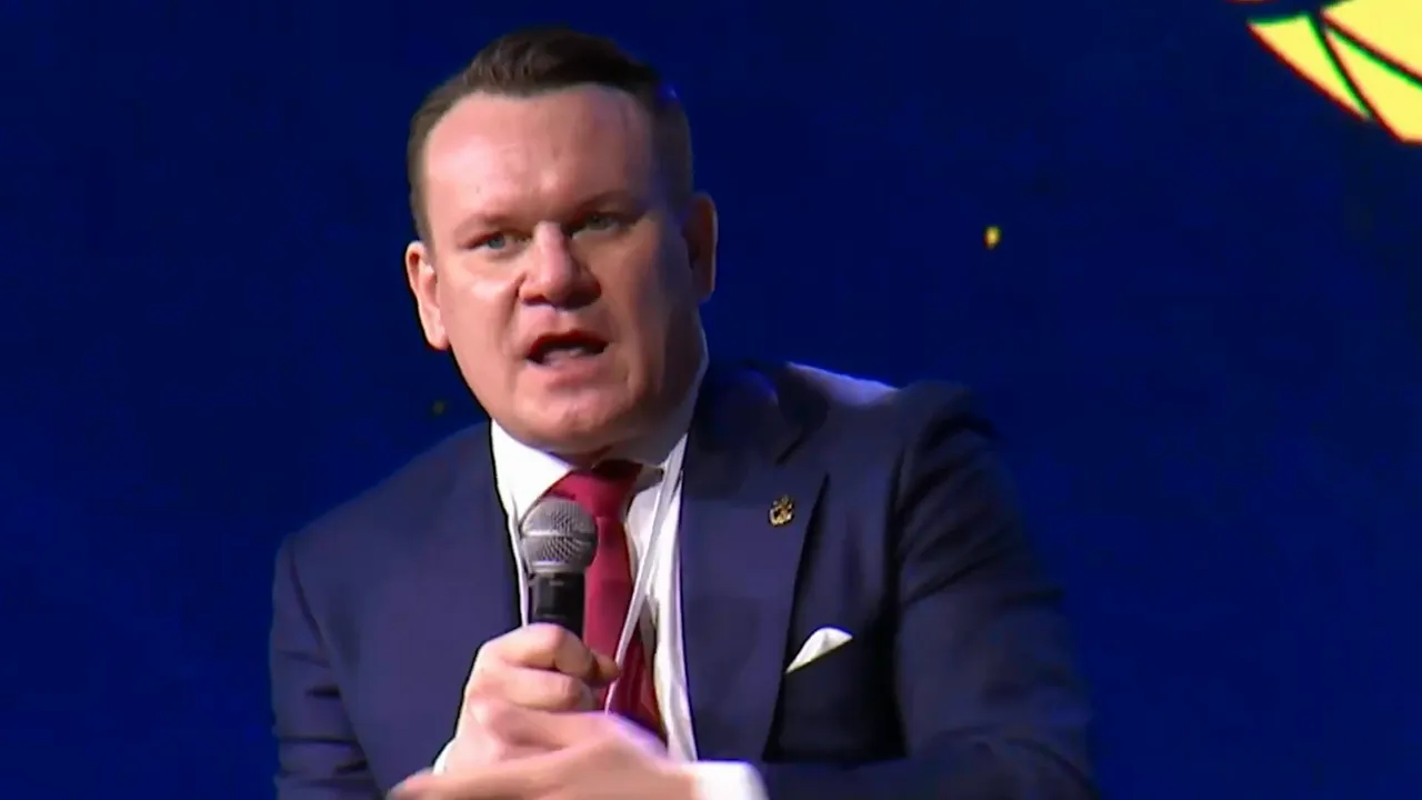 Politician speaking into a microphone onstage during a speech