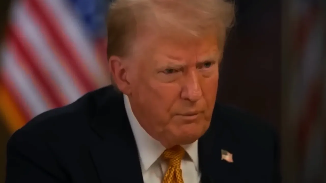 Close, clear interview portrait of a senior male politician with flags in the background