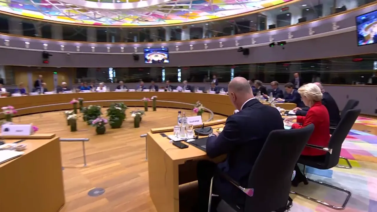 Wide shot of a roundtable summit in a council chamber with leaders seated around and a colorful ceiling above.