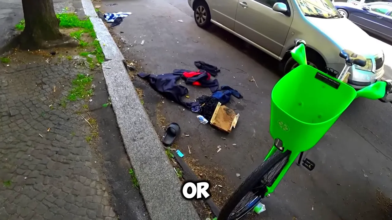 Street with scattered belongings and litter near the curb suggesting public disorder