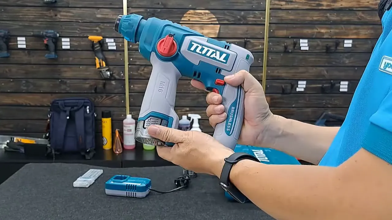 Cận cảnh hai tay cầm máy khoan Total, hiển thị vị trí pin và nút chức năng