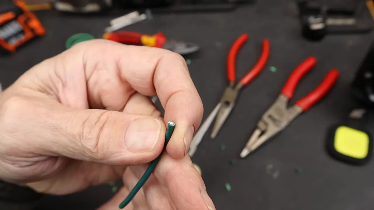 Cận cảnh đầu dây nhiều sợi màu xanh hiển thị lõi kim loại và lớp vỏ sau khi cắt