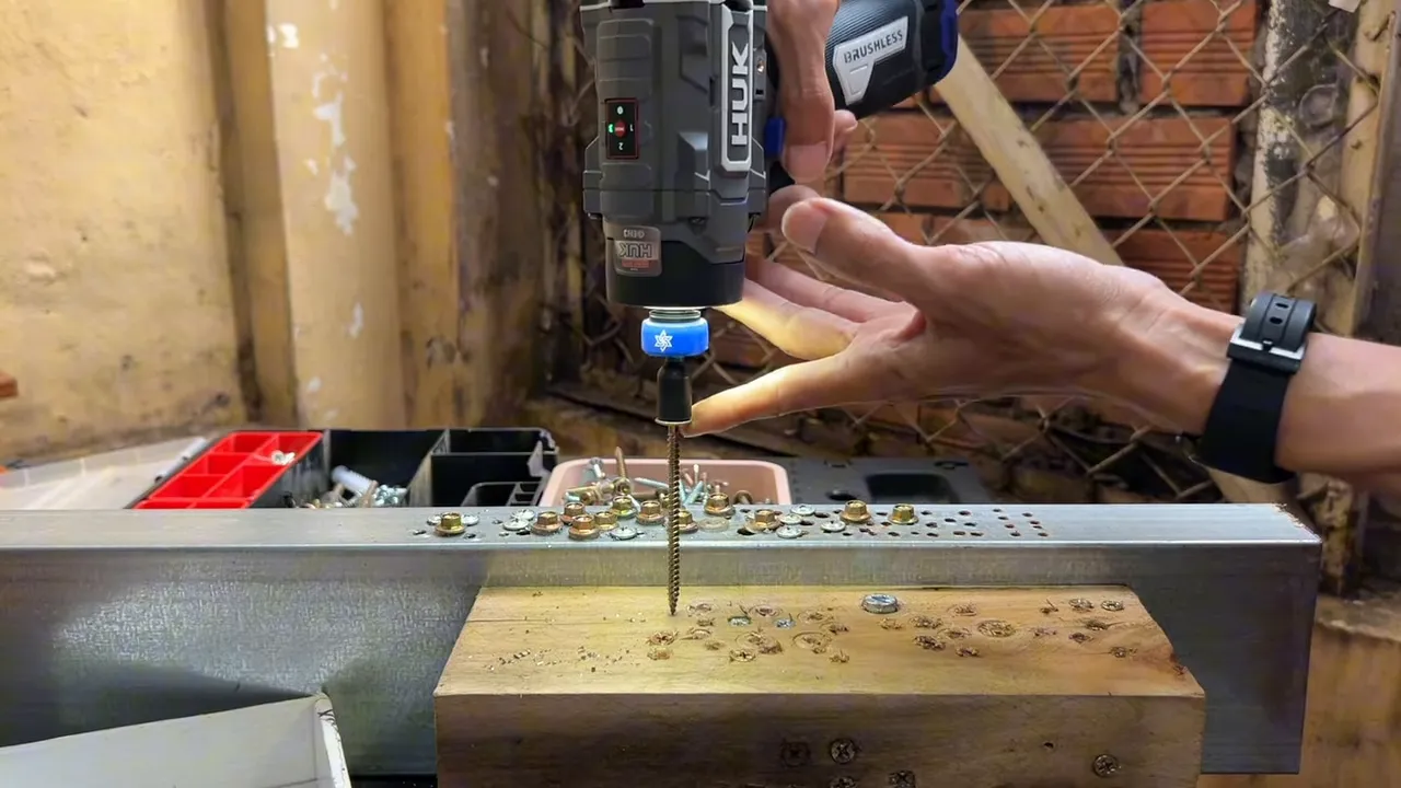 Hunkan 160 đang bắn vít thẳng vào gỗ, đèn LED bật, tay giữ máy phía trên
